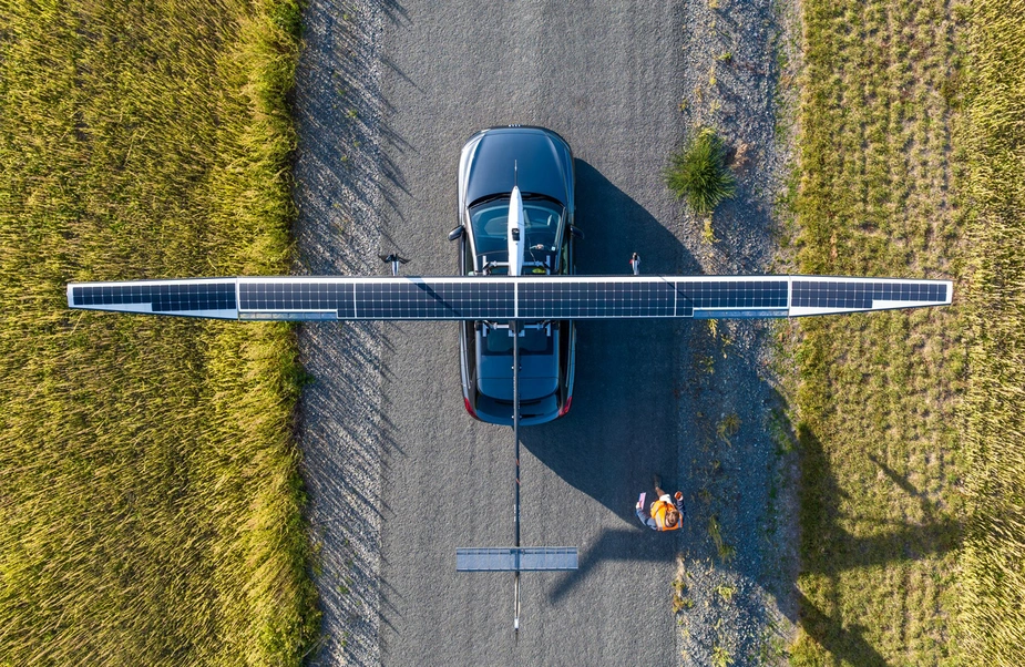 Auto auf einer Straße von oben mit einem solarbetriebenen Fluggerät auf dem Dach