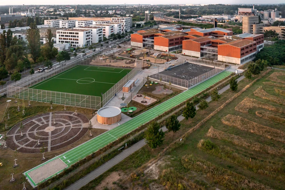 Luftbild mit verschiedenen Sportfeldern und der Schule im Hintergrund