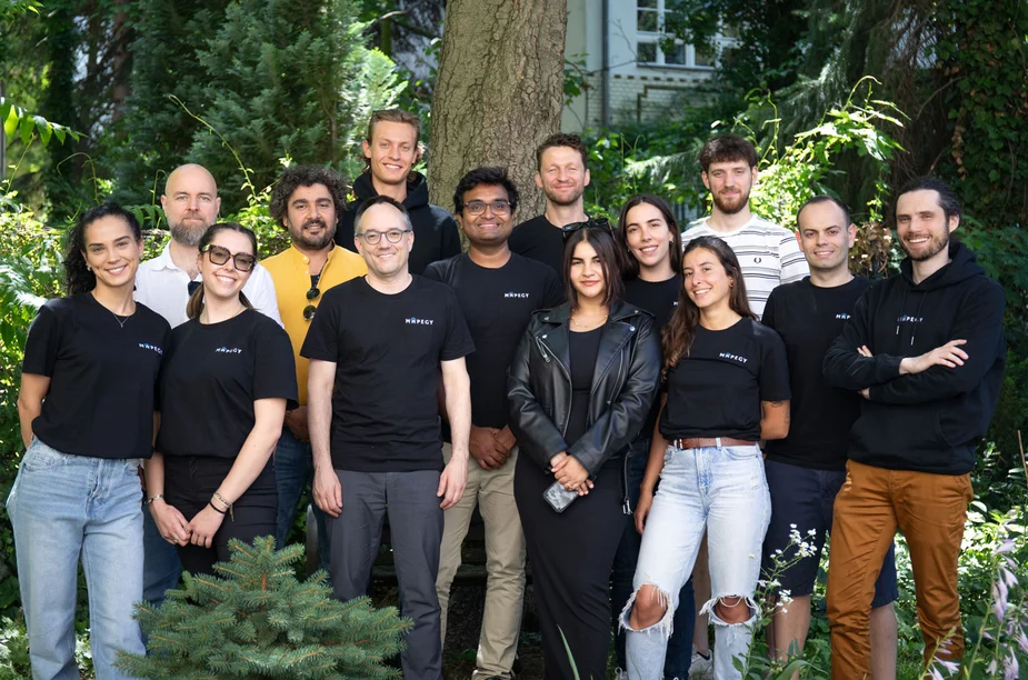 Das 14-köpfige Mapegy Team steht im Grünen inmitten von Bäumen , Bild: MAPEGY