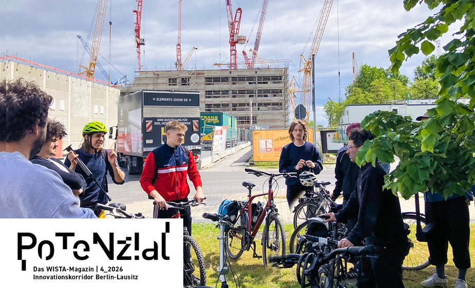 People stand with their bicycles in front of a building site