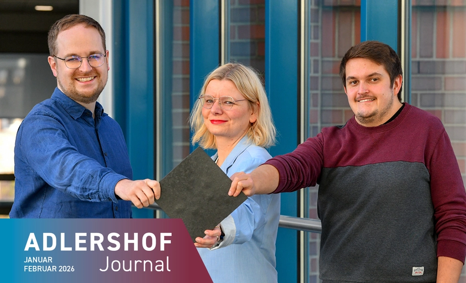 Three people show a square, dark, approx. 20 cm large plate.
