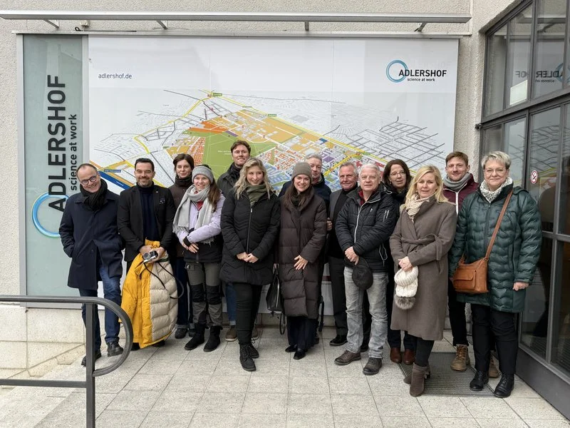 Besuchsgruppe steht vor einem Lageplan des Technologieparks Berlin Adlershof