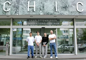 Vier Personen stehen vor dem Eingang des Charlottenburger Innovations-Centrums unter dem Schriftzug CHIC