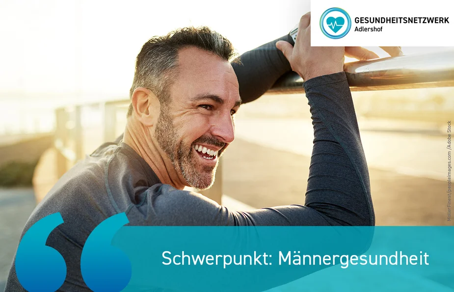 Mann lehnt lächelnd an einem Geländer im Sonnenlicht.