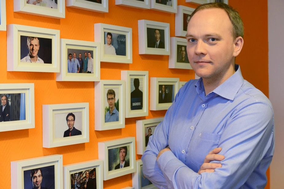 Volker Hofmann vor der Bildergalerie der Start-up-Gründer, denen die Humboldt-Innovation GmbH auf die Sprünge half. Bild: © Adlershof Journal