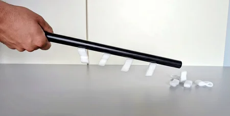 Hand mit einem Plastikstab, an dem Styroporflocken haften