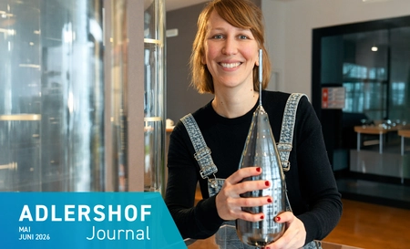A young woman is holding a large, bottle-shaped crystal in her hands