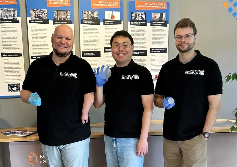 The three founders hold up wafers to the camera