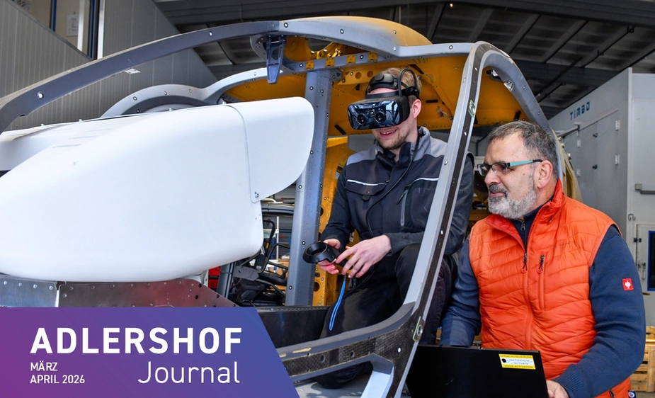 Man with VR glasses and control device, another man watching