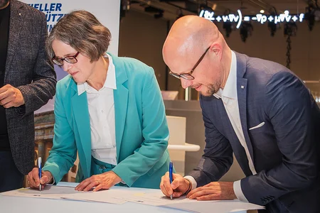 Two people are signing contracts