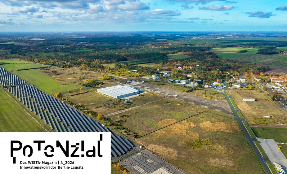 Aerial view of a landscape featuring scattered buildings and a solar farm