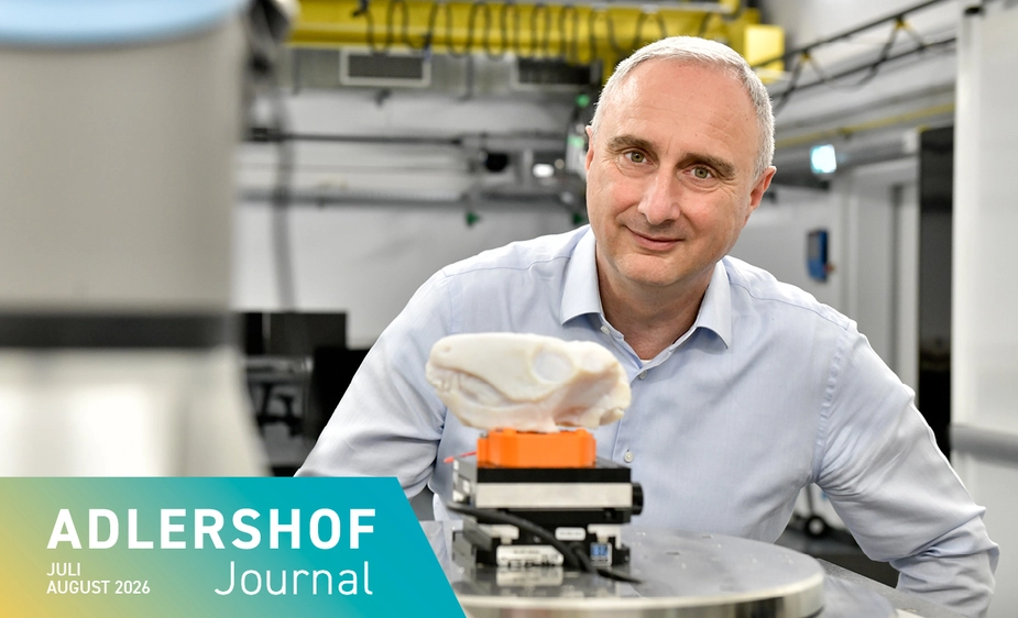 Researcher at a piece of equipment with a small skeletal head on it